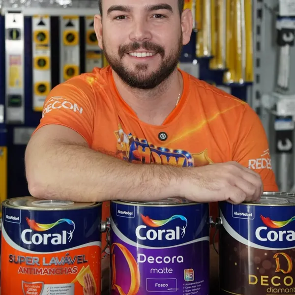 Atendente da Eletrocenter com latas de tinta no balcão