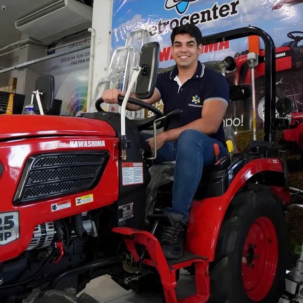 Vendedor em um trator vermelho exposto na Eletrocenter