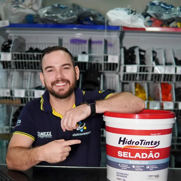 Atendente apontando para um balde de selador acrílico